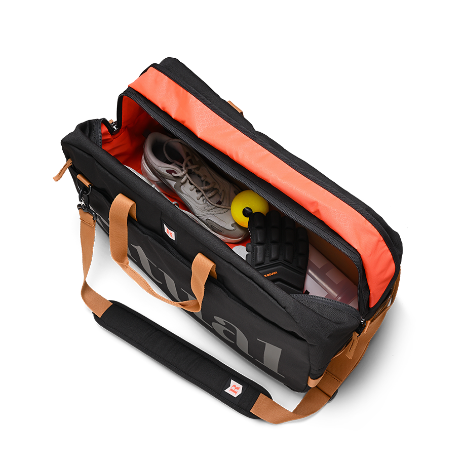 Ritual Calibre hockey duffle bag black with orange interior showing shoes and a ball, top view