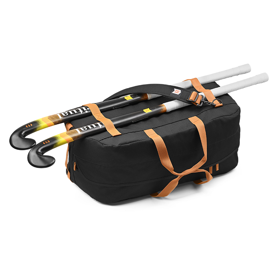 Ritual Calibre hockey duffle bag black with orange straps holding multiple hockey sticks