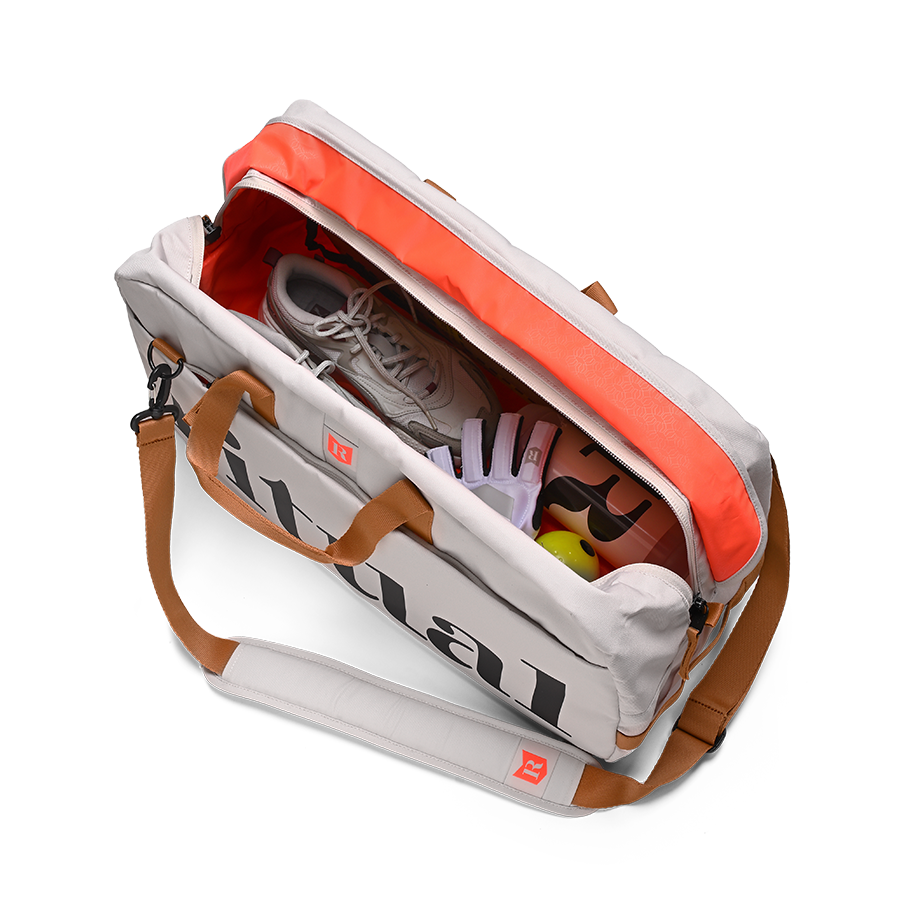 Ritual Calibre hockey duffle bag white with items including a shoe, sunglasses, and a towel, top view