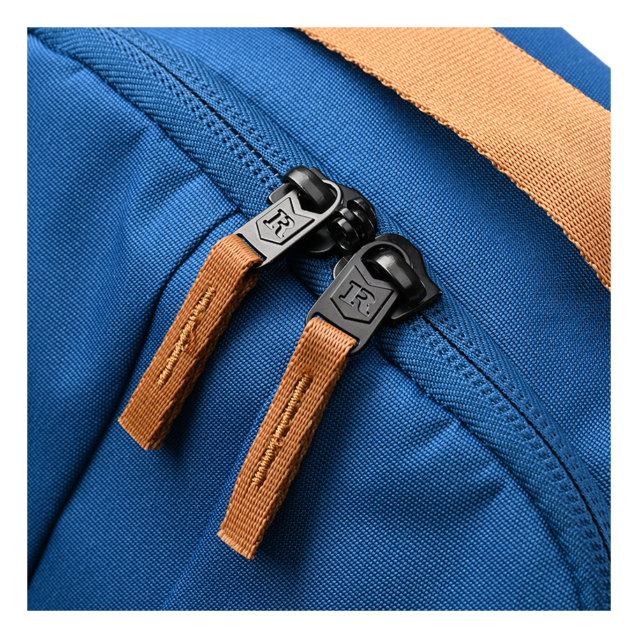 Ritual Covert hockey backpack blue with brown straps and black zippers, closeup view